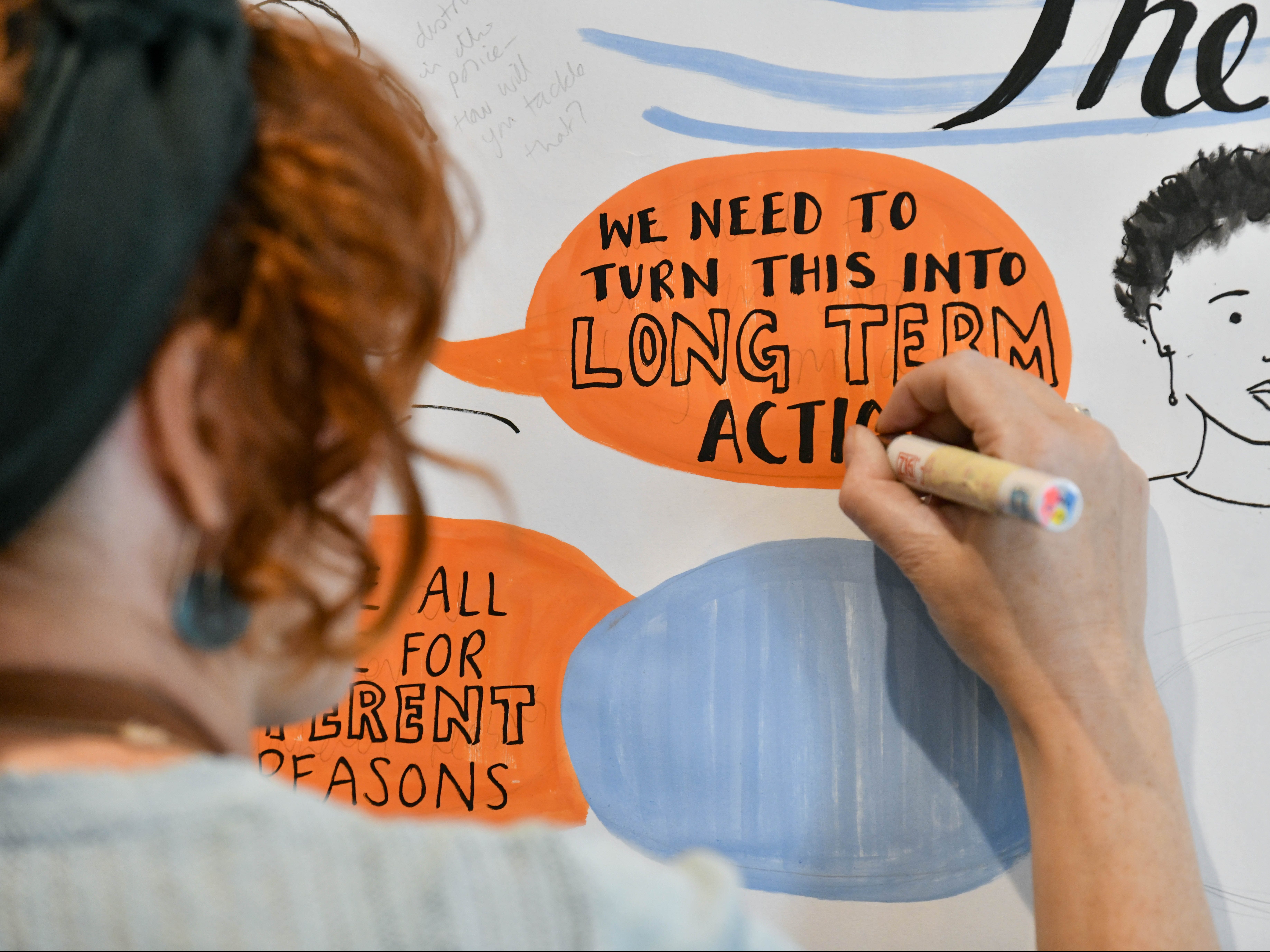 close up of poster reading we need to turn words into long term action